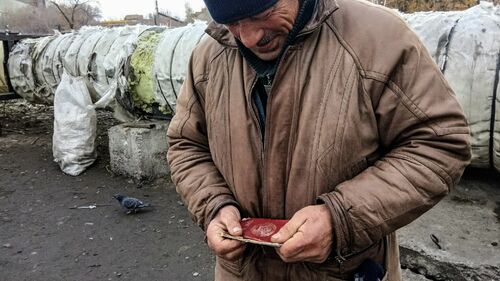 старый бомж сидит один на улице